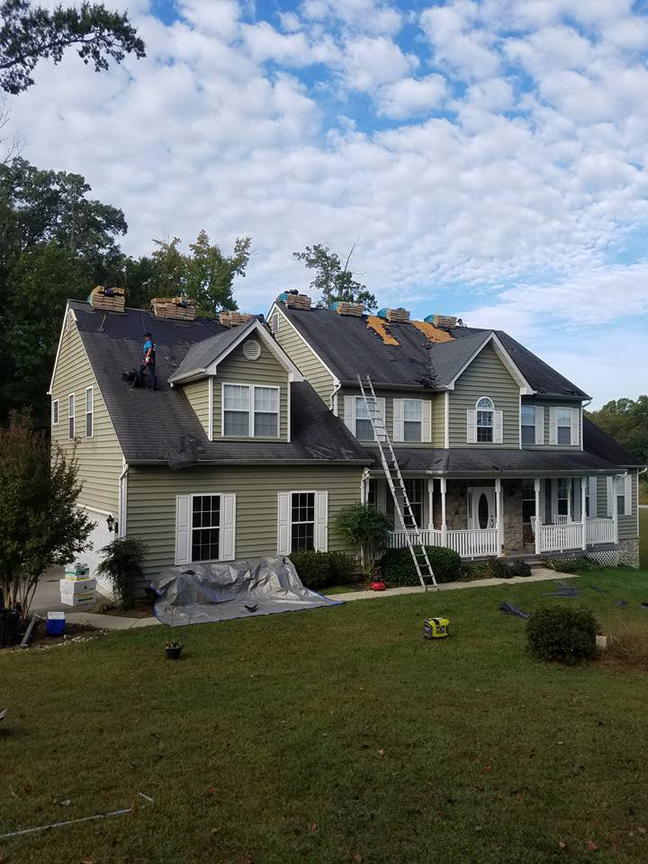 House with workers doing the roofing