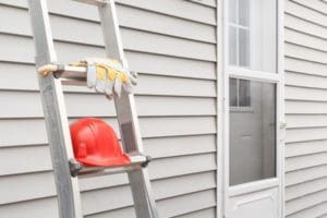 Latter leaning against a house with siding