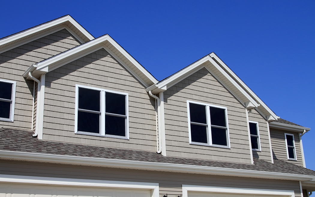 House with light gray siding and windows on the front