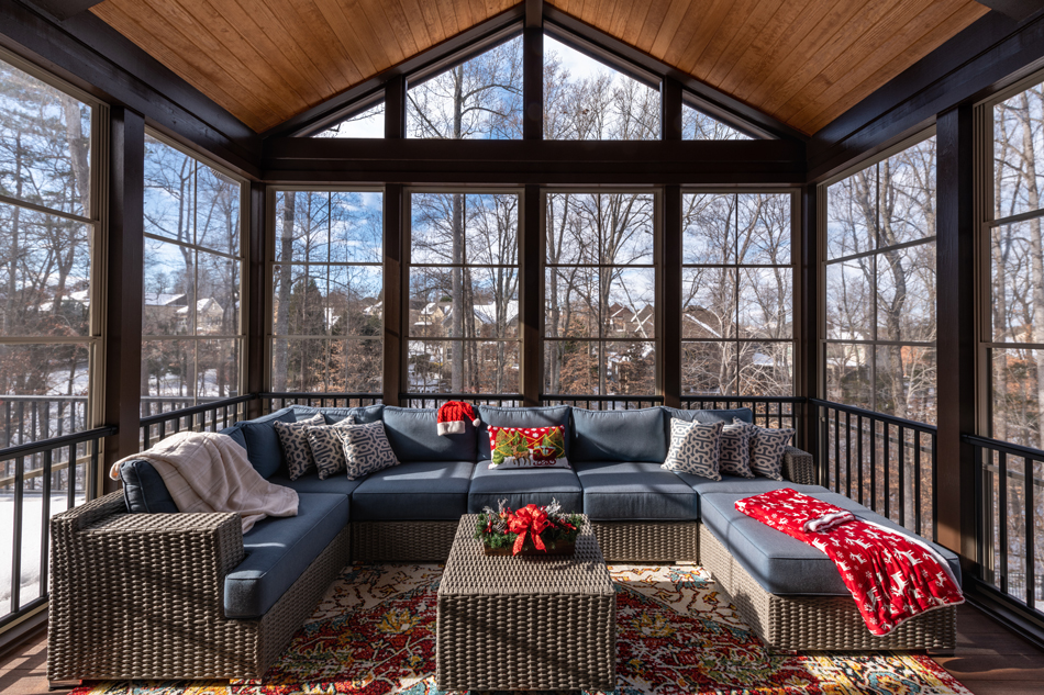 Cozy-Porch-Enclosure-in-Winter-1365227344 Cozy screened porch winter during Holidays season, snowy roofs and woods in the background.